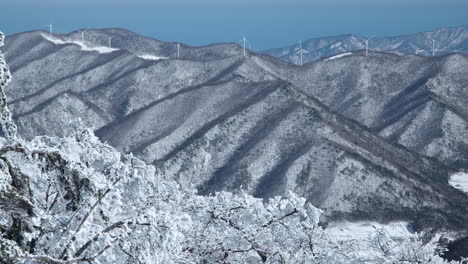 balwangsan mountain view on snowcapped daegwallyeong mountains valley with huge wind turbines farm on summits in pyeongchang-gun, gangwon-do, south korea