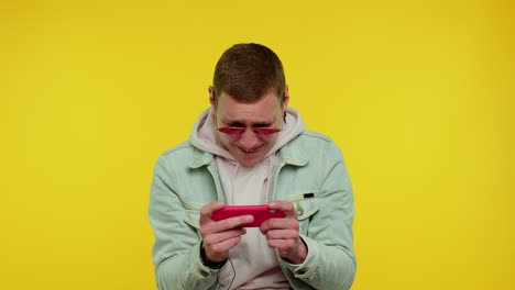 worried funny addicted teen boy enthusiastically playing drive racing video games on mobile phone