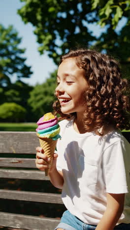 a young girl enjoying colorful ice cream in a park on a sunny day