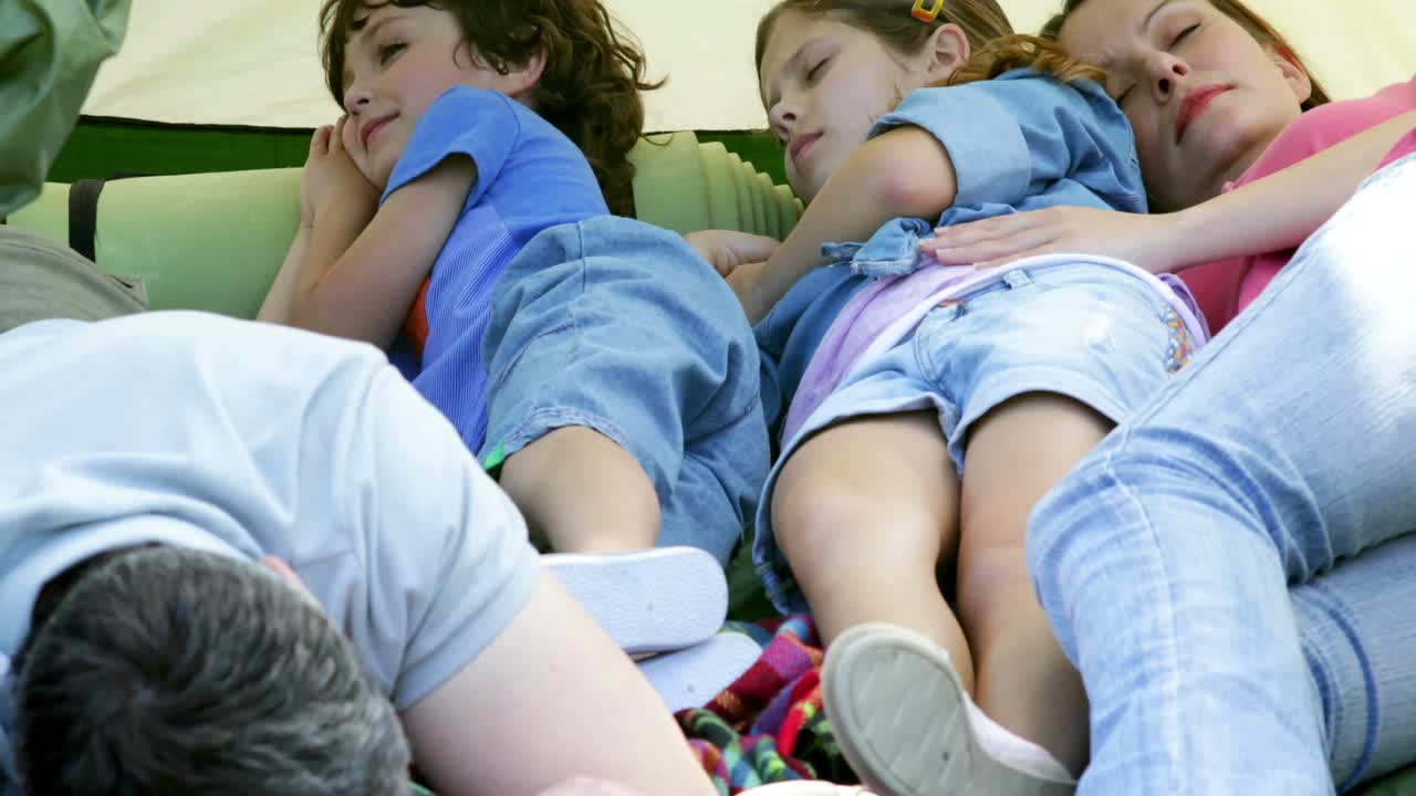 평화로운 가족 이 캠핑 여행 에서 텐트 에서 낮잠 을 자고 있다