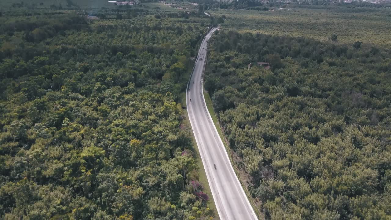 vista aérea de drones de una calle en medio del bosque que revela un volcán en guatemala