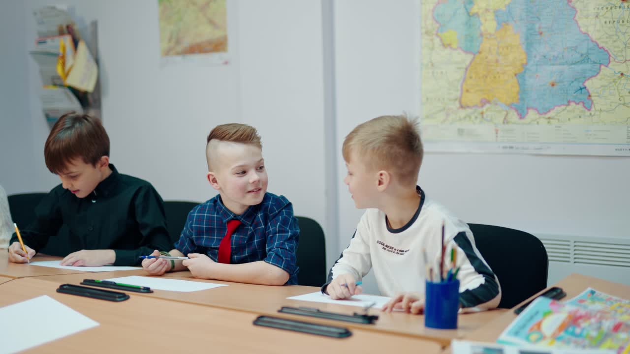 Active children in classroom. Little boys sitting at desk and listen to the teacher at school. Happy school children study. Primary education concept.