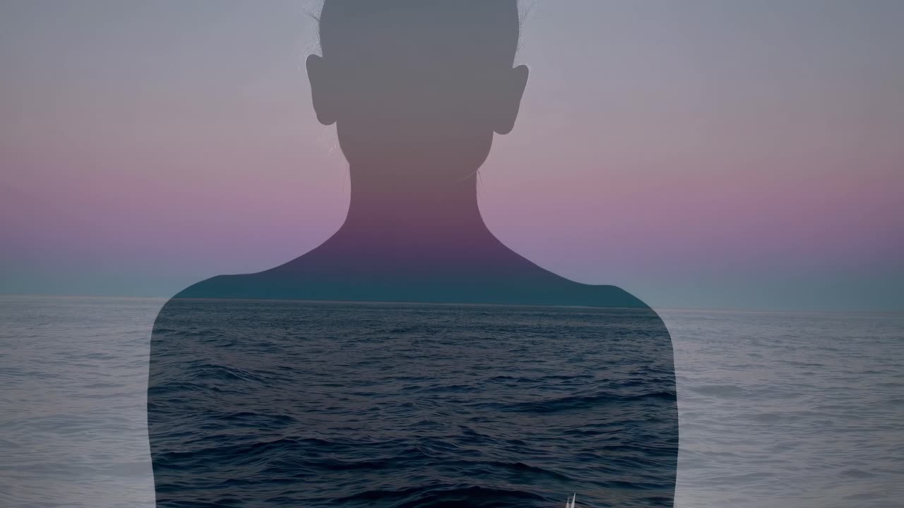 Silueta de una persona con un vídeo de paisaje marino superpuesto, creando un concepto de vídeo sereno e introspectivo