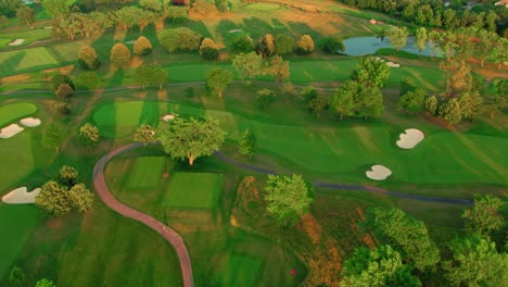 Overview-of-a-golf-terrain,-aerial-revealing-enormous-size-of-the-golf-terrain-in-the-evening