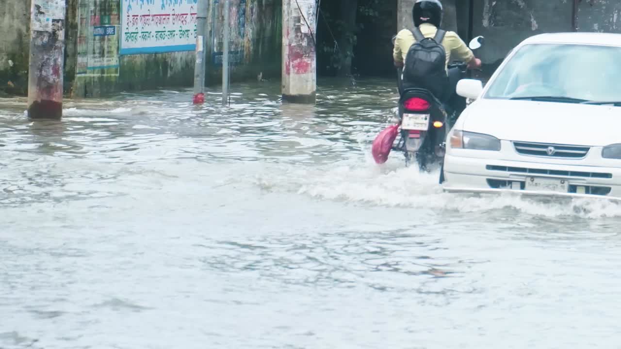 Traffic driving through rising flood water in Sylhet Bangladesh after monsoon storm crisis
