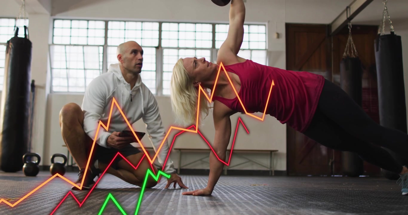Kvindelig kunde i fitnesscenter starter sideplank-roning med kettlebell, træner optager med tablet, diagram sporer gentagelser.