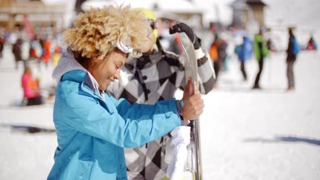 Man-flirting-with-woman-holding-snowboard