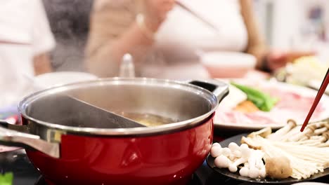 friends enjoy hotpot meal with fresh ingredients