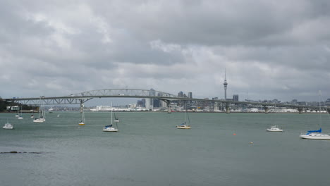 Lapso-De-Tiempo-De-Auckland-Con-Yates-Y-El-Puente-Del-Puerto-De-La-Ciudad-En-Un-Día-Nublado-En-Nueva-Zelanda