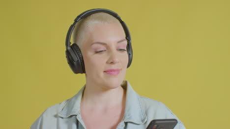 Female-caucasian-model-listening-to-music-on-headphones-studio-portrait-04