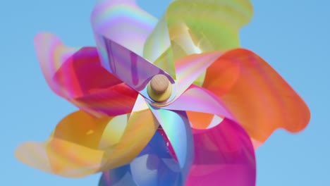 rotating plastic pinwheel with blowing wind stands against the background of blue sky and the horizon slow motion summer. toy mill on beach. copy space. pattern