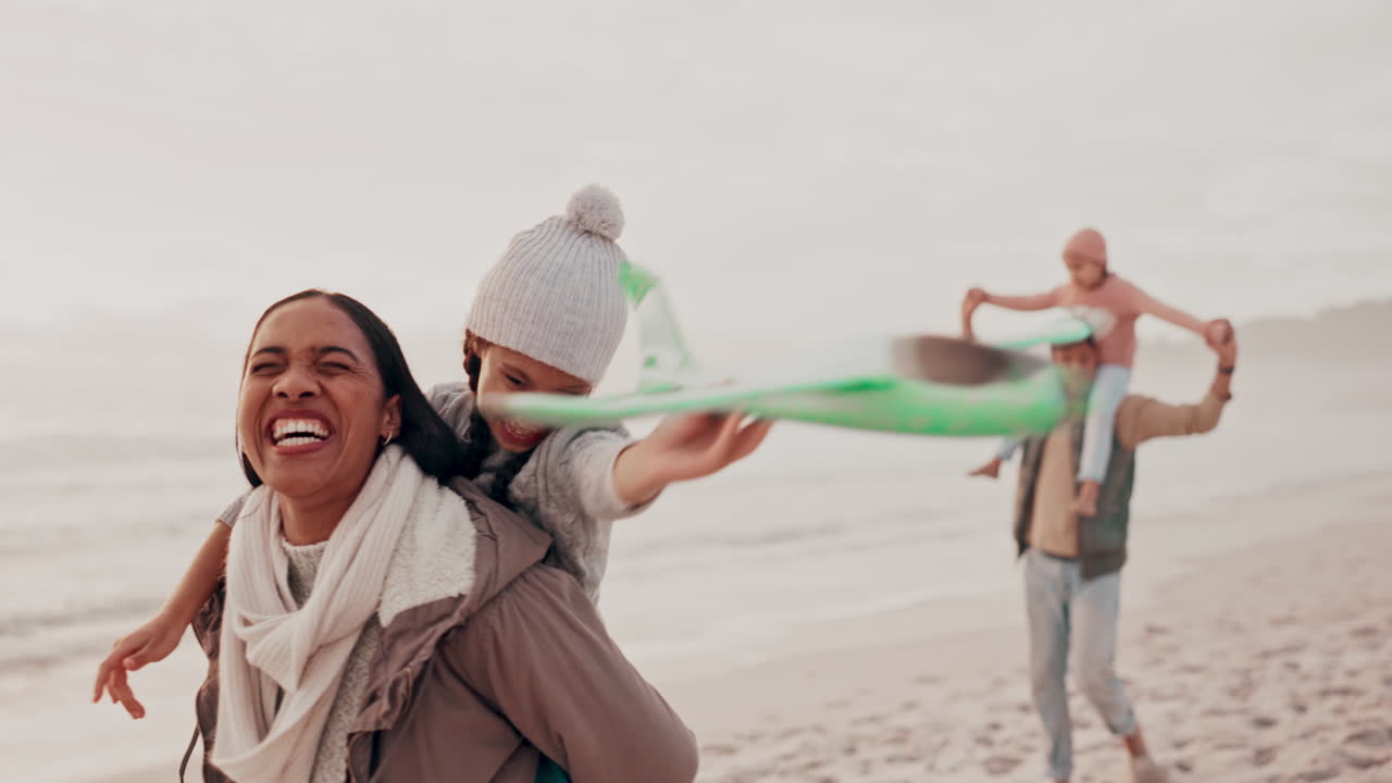 madre e hija disfrutando de un día en la playa con una cometa