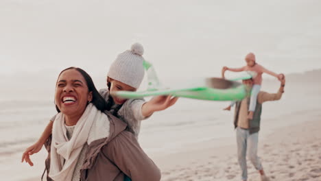 madre e hija disfrutando de un día en la playa con una cometa