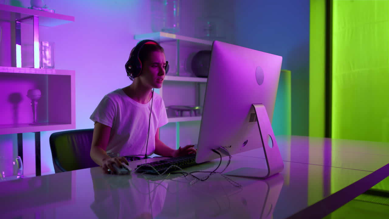 ragazza eccitata che gioca a esport online nella stanza del cyberspazio. giocatore al neon con le cuffie