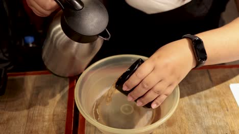 person pouring liquid from a kettle