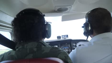 una toma en cámara lenta de un piloto y un copiloto uniformados aterrizando un cessna
