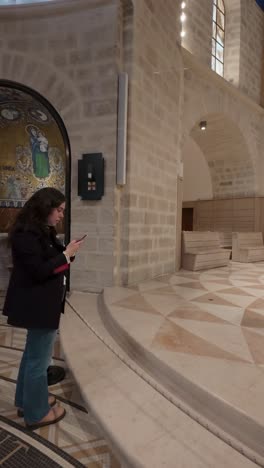 young woman using smartphone in dormition abbey, jerusalem. slow motion.