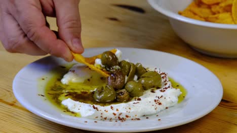 the chef dips chips into yogurt sauce