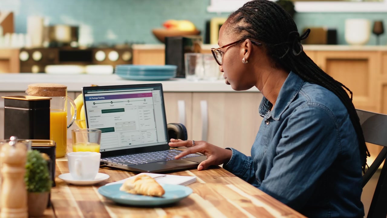 Cliente afroamericano che controlla la spedizione tramite numero di tracciamento su software