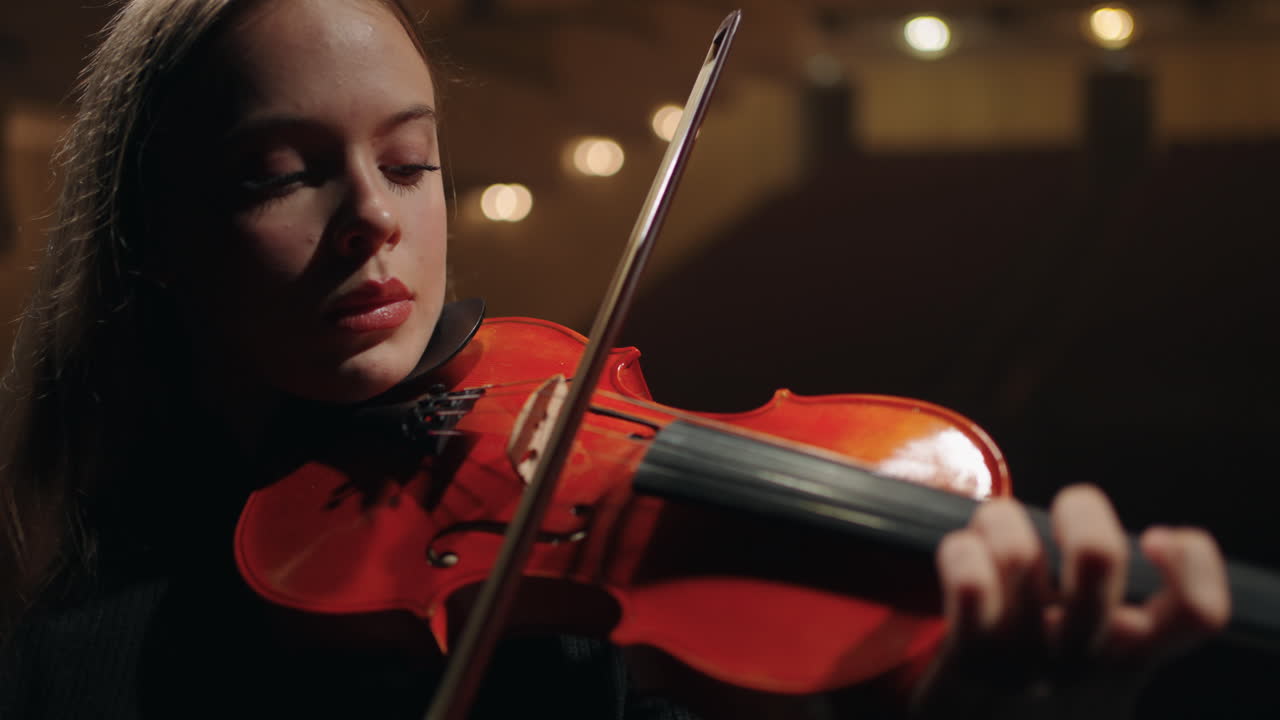 una joven violinista está interpretando una sonata en una sala de música retrato en primer plano de una violinista
