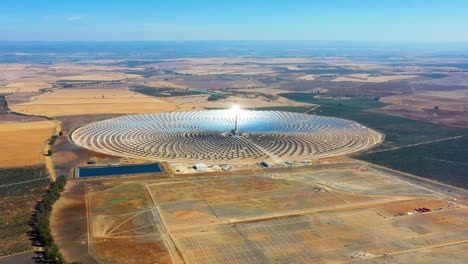 planta de energía de paneles solares fotovoltaicos. planta de energía termosolar, un centro de granja solar rodeada de campos - vista panorámica con un dron - concepto de medio ambiente