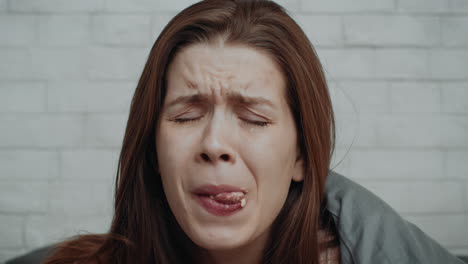 woman crying in bed, possibly sick