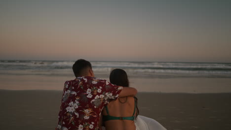 Happy-couple-sitting-on-the-sand