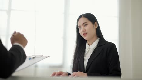 smart asian woman to greet a hr staff before a job interview to apply for a job. happy woman seeker or insurance broker presenting a business deal. business woman sending resume.