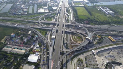 aerial view of highway road interchange with busy urban traffic speeding on road