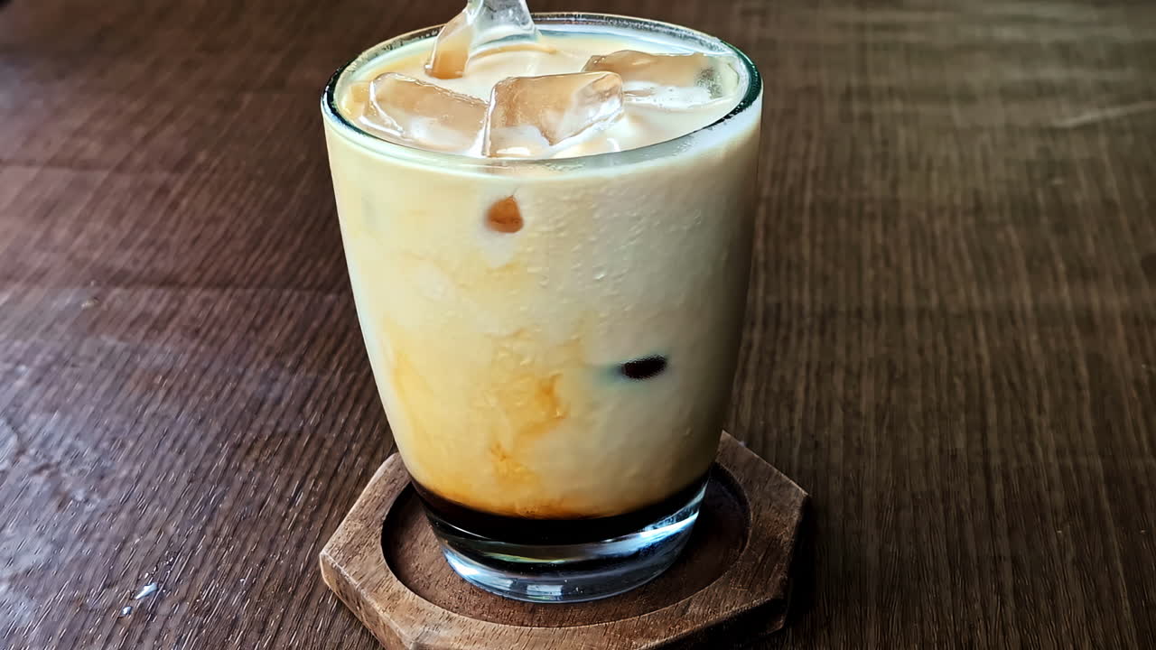 Closeup footage cold coffee with ice on top served.