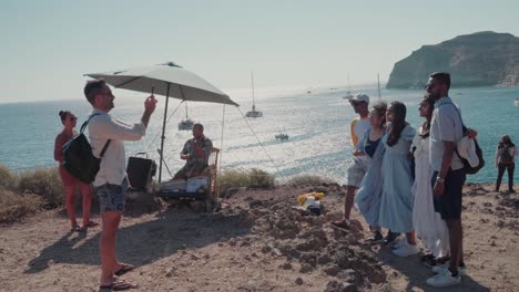 group of tourists taking photos on a cliffside overlooking the ocean