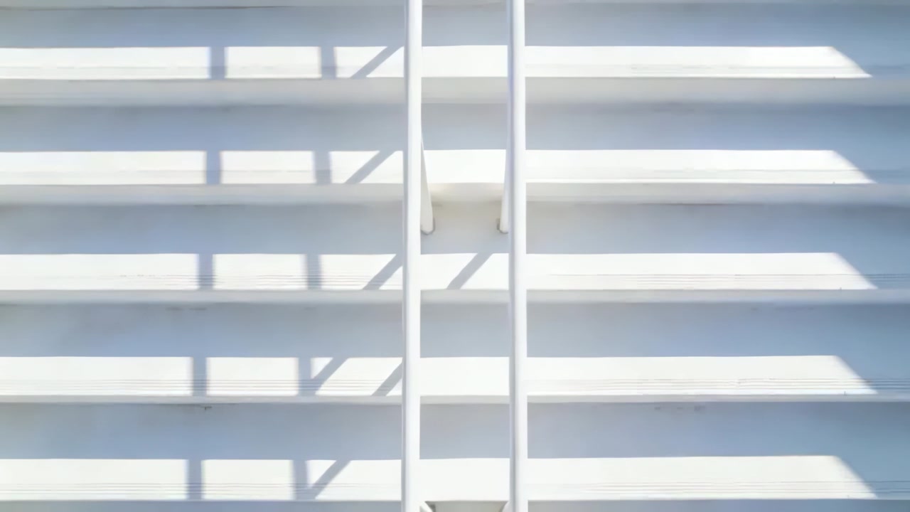 Sun moving, shadows shifting across building louvers, center rails with brackets showing time