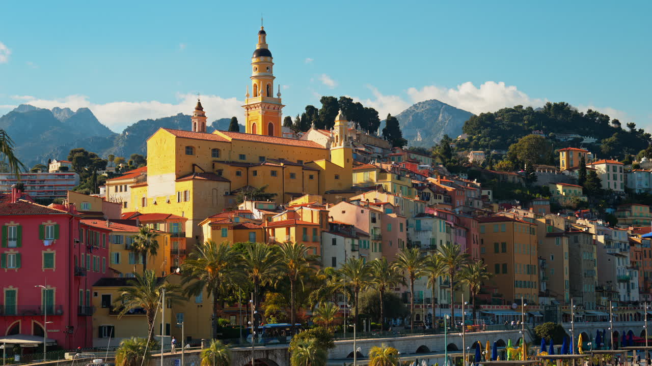 Distant view of the St Michel Basilica surrounded by colourful buildings, Menton, France
