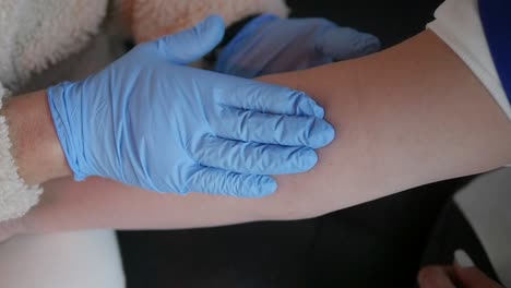 blood sample, nurse tapping the arm to find a good vein to draw blood during venipuncture