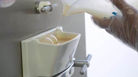 pouring creamy gelato base into spout for gelato batch freezer machine