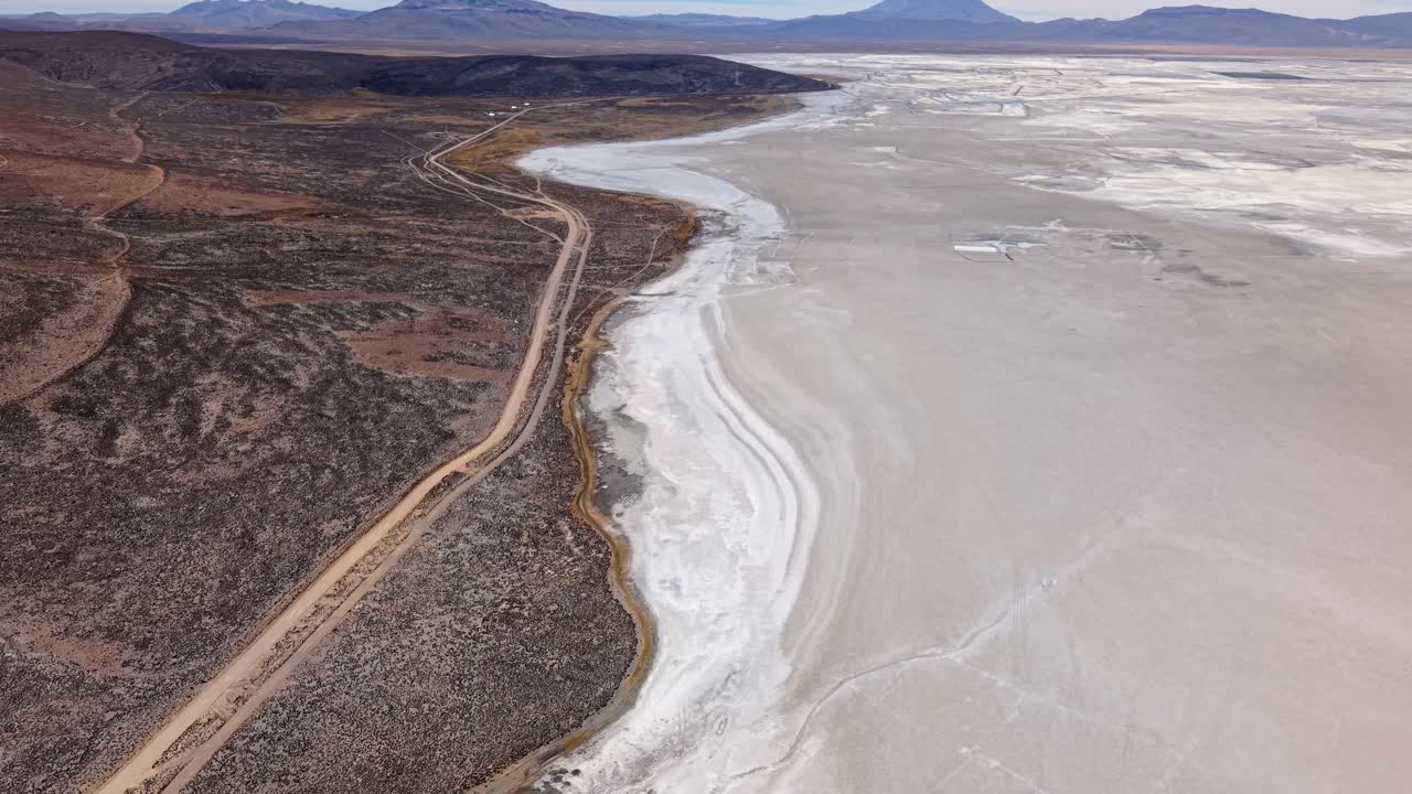 Veduta aerea di una strada di accesso a una salina e un lago peruviani d'alta quota.