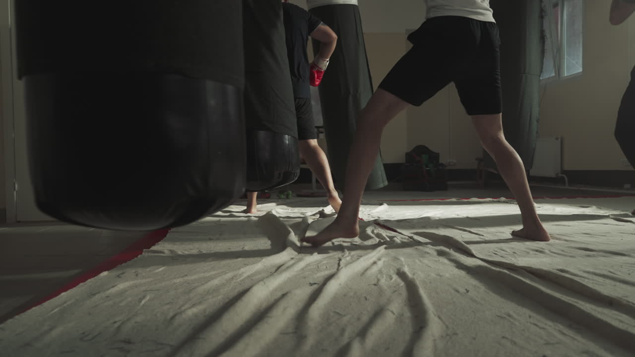 남자 그룹 운동은 공중 체육관에서 치백과 함께 클로즈업. 강한 박스 선수는 싸움 클럽에서 카에서 운동하는 동안 기법에 대해 느린 동작을합니다.