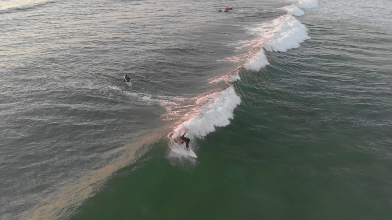 Surfing - Skilled Surfers Riding The Ocean Waves In Algarve, Portugal. - aerial drone shot