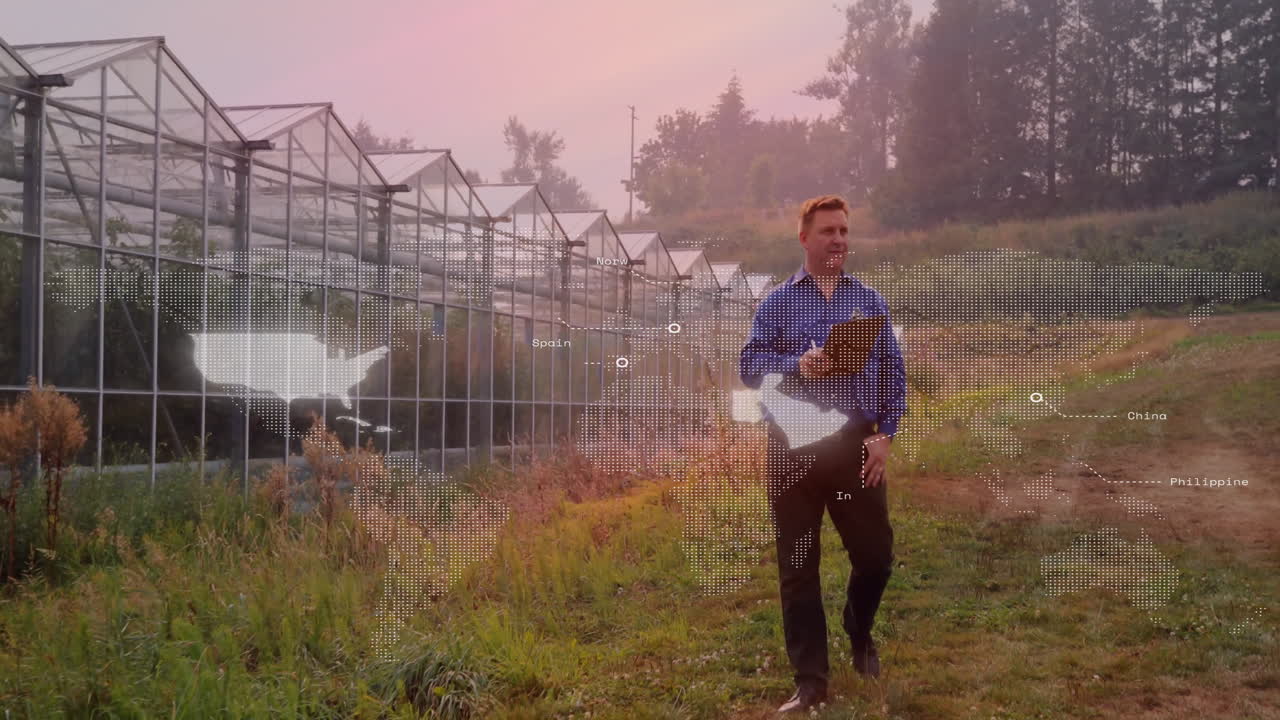 Walking near greenhouses, man with world map animation overlay in background