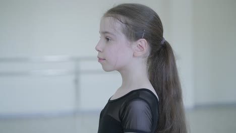 young ballerina practicing dance moves in studio