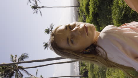 primer plano de cardán de una mujer rubia mirando la cámara en un paisaje de playa