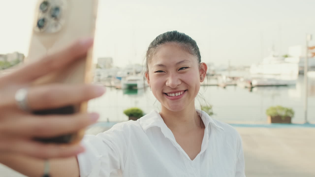 Asian woman taking a selfie in a marina