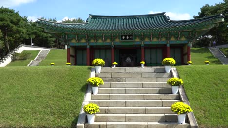 walking towards traditional korean building in chilbaek cemetery park