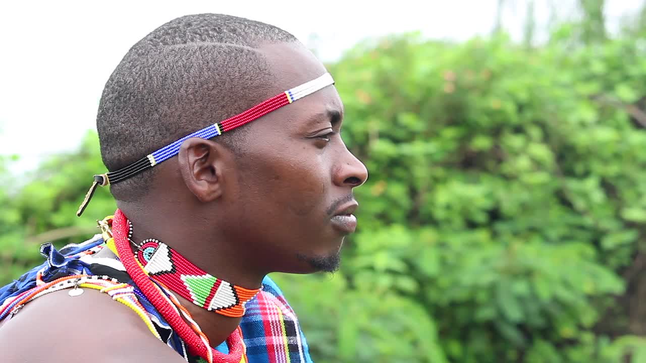 Nuori maasaimies kuuntelee, kun joku muu puhuu.