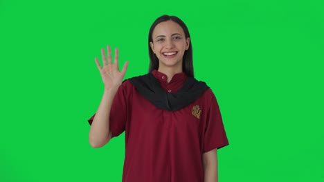 happy indian female housekeeper waving hello green screen