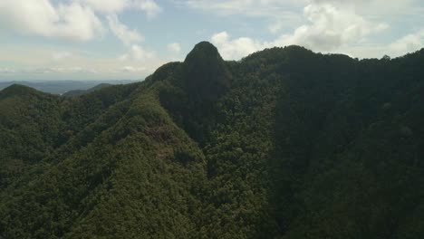 aerial left to right pan of rain forest covered mountain on a tropical island in thailand