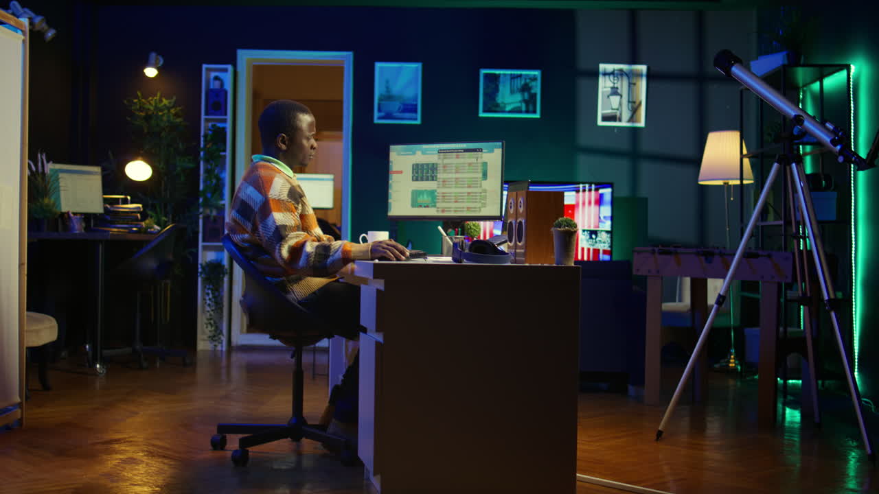 Man working on computer in dark home office