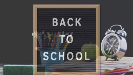 volver al texto de la escuela en la pizarra contra la paleta de colores y el icono de instrumentos geométricos