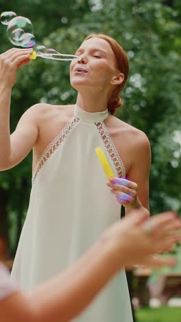 woman and child blowing bubbles in a park