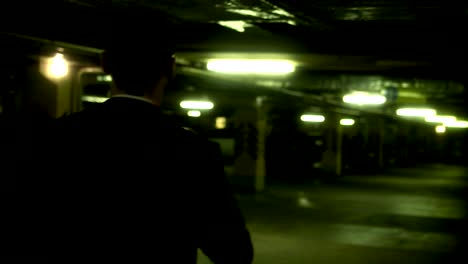 businessman walking through a dark parking garage at night